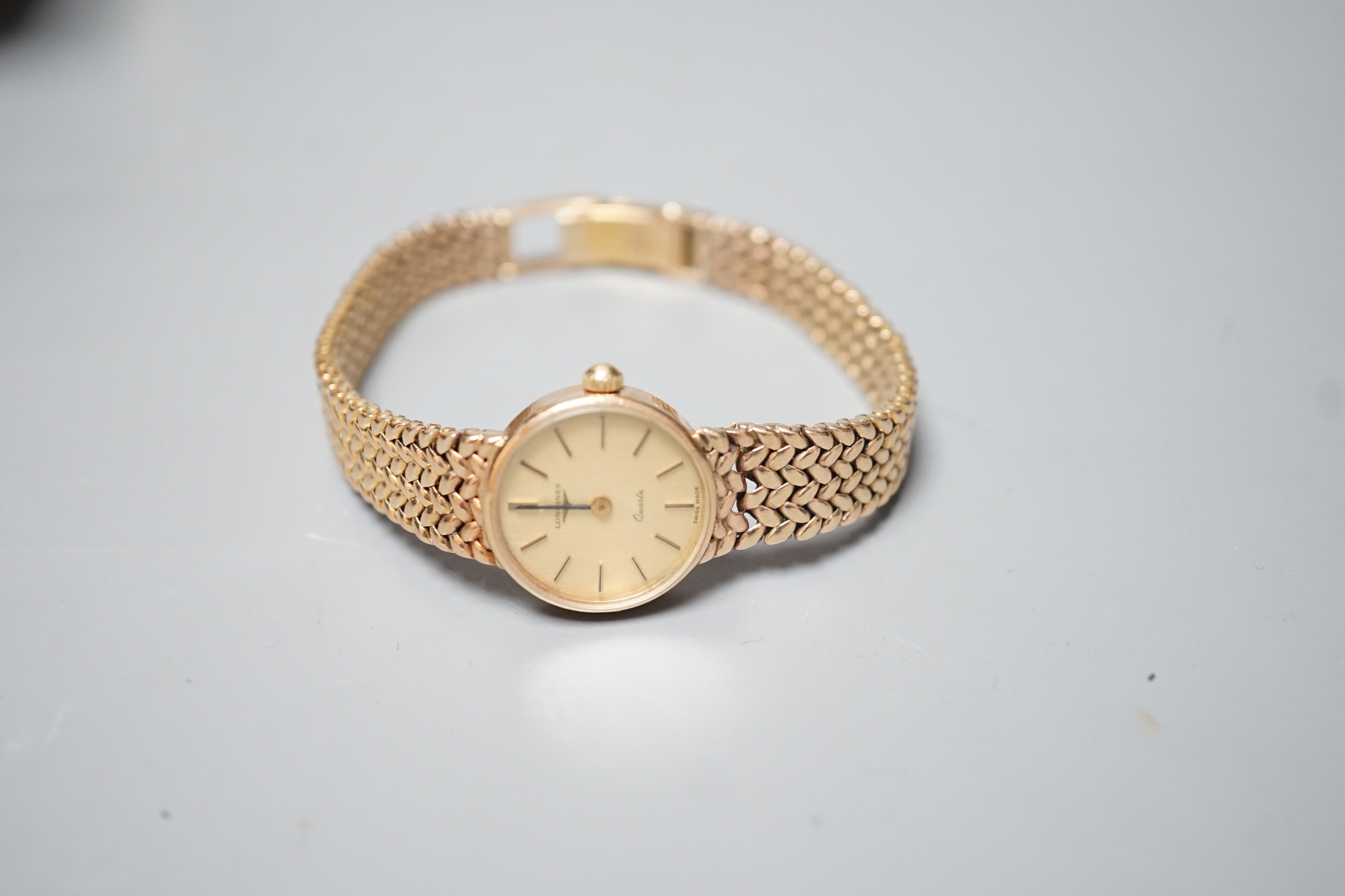 A lady's 9ct gold Longines quartz wrist watch on an inegral 9ct gold bracelet, with Longines box